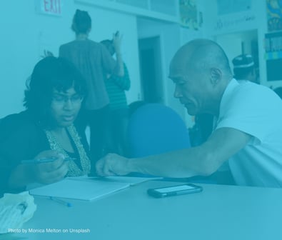 Woman and man sitting at a table and collaborating on a project together